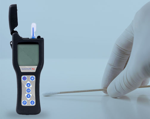 ATP Meter off to the left with a white latex handing holding a q-tip off to the right