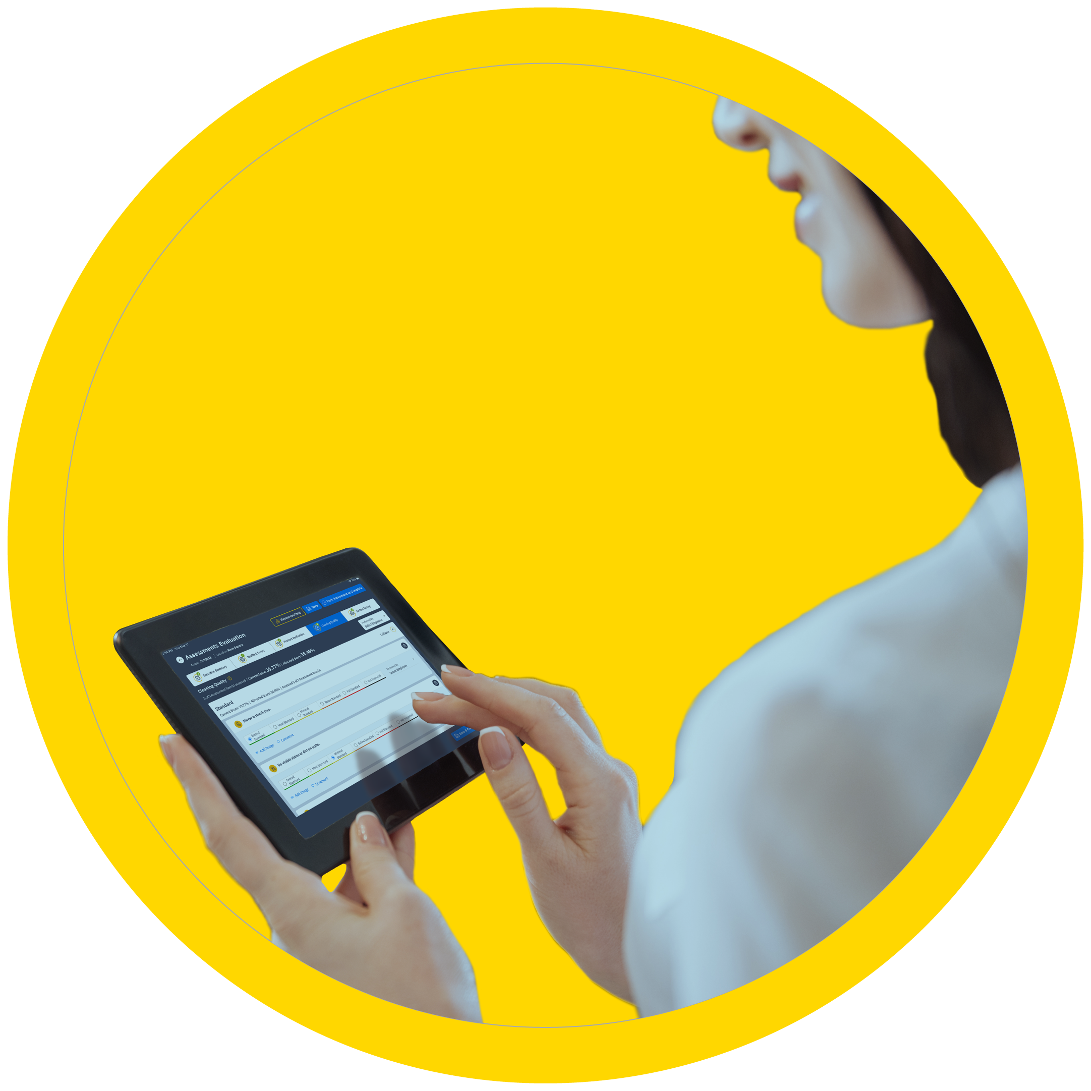 A female in a white shirt is holding an iPad in her left hand while her right hand goes to click on an assessment from the SAVI software to review more details.